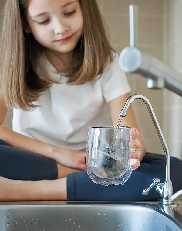 Une petite fille se sert un verre d'eau